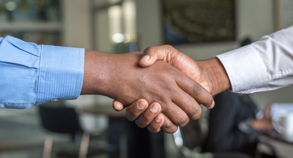 Close up of the hands of two people shaking hands.